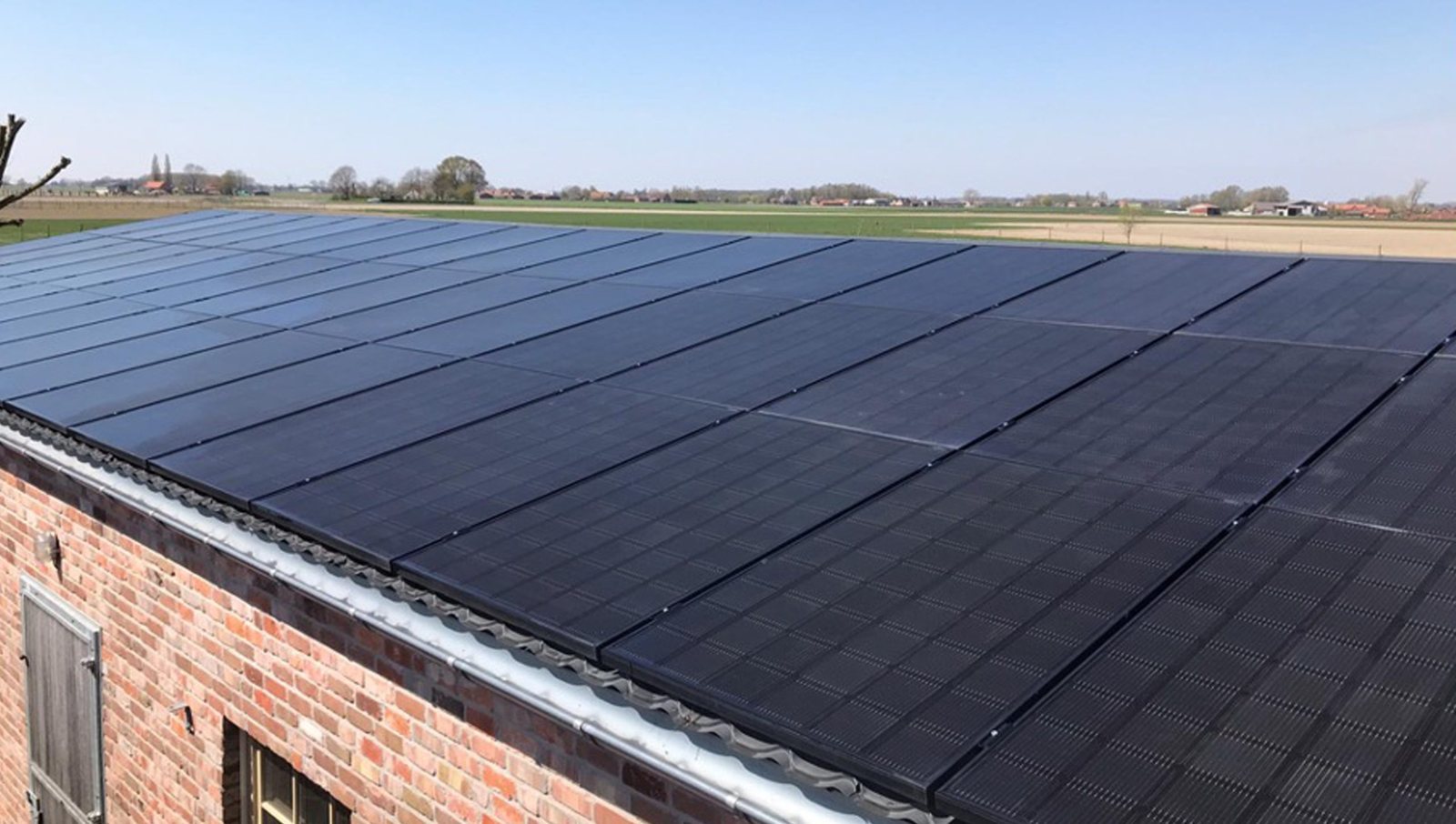 Zonnepanelen op een dak met bakstenen gevel
